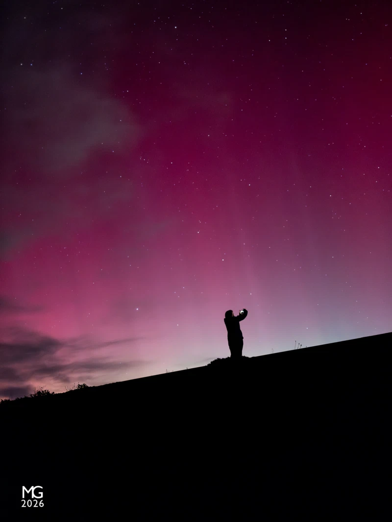 Capture Standing on the railway embankment near the Gembrook football ground, one of the locals is silhouetted against the aurora-filled sky.