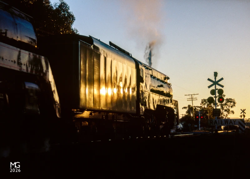 Glinting Departing Stawell for their overnight stop at Dimboola, 3801 and 3830 glow in the late evening sun as they cross the level crossing at Lake Road.