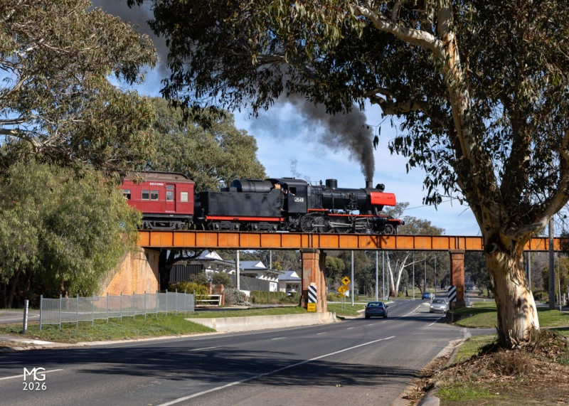 McKenzie Hill On the outskirts of Castlemaine, J549 crosses over the Pyrenees Highway with the 10:45 departure for Maldon.The morning sunlight highlights the distinctive SCOA-P driving wheels; developed by the Steel Company of Australia as part of the R class development in the late 1940s, these used U-shaped spokes to strengthen the wheel without adding excessive weight.