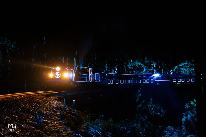 Big drop LED lights paint the valley floor as NG/G16 129 crosses the Wright trestle bridge with one of the Train of Lights specials.